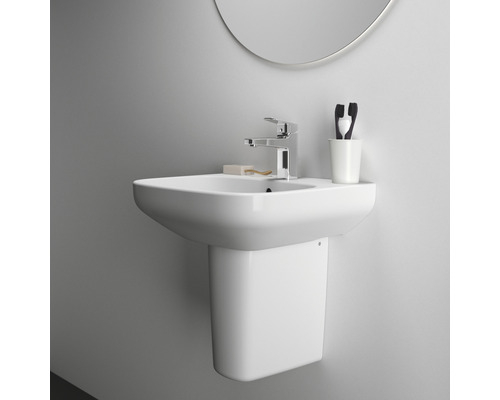 Lavabo en céramique avec robinet et demi-colonne dans la salle de bain.