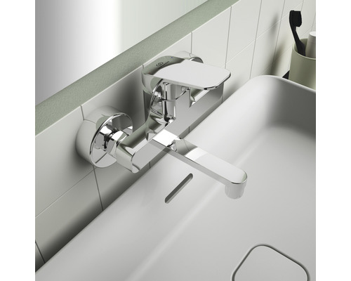 Robinet de lavabo mural en métal sur un lavabo