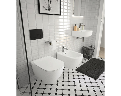 Helles Badezimmer mit Toilette, Bidet, Waschbecken und schwarz-weiß gemusterten Fliesen