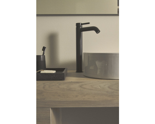 Waschtischarmatur und Waschbecken auf einem Holztisch mit Seife und Zahnbürste