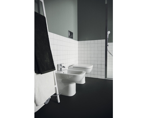 Salle de bain avec bidet, toilettes, porte-serviettes et carrelage