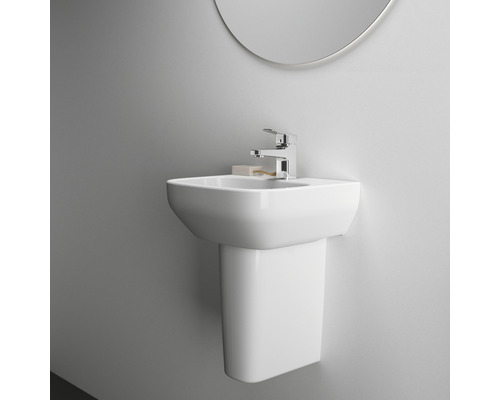 Lavabo en céramique avec robinetterie et miroir fixé au mur