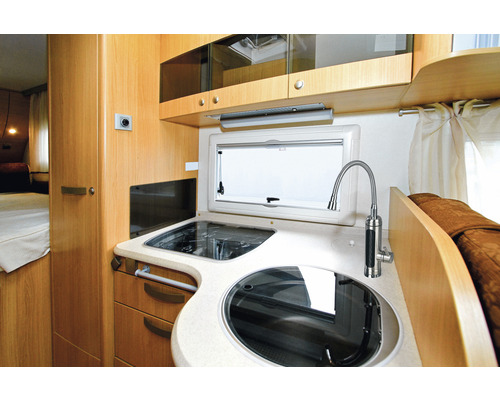 Küchenbereich im Wohnmobil mit Spüle, Herd und Küchenfenster