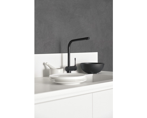 Schwarzer Wasserhahn neben Geschirr in einer modernen Küche