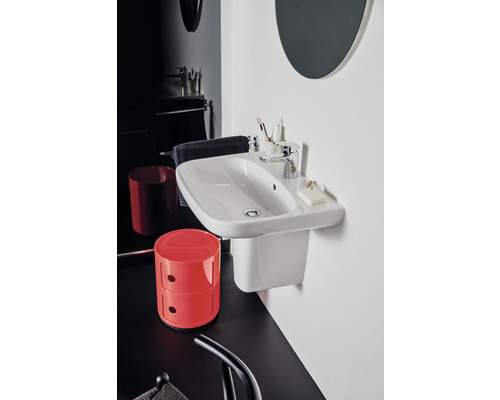 Salle de bain moderne avec lavabo blanc et espace de rangement, armoire rouge et sol noir