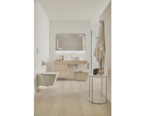 Salle de bains lumineuse avec toilettes, meuble-lavabo, miroir et accessoires