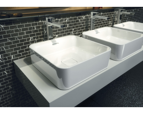 Trois vasques à poser sur un support blanc dans la salle de bains