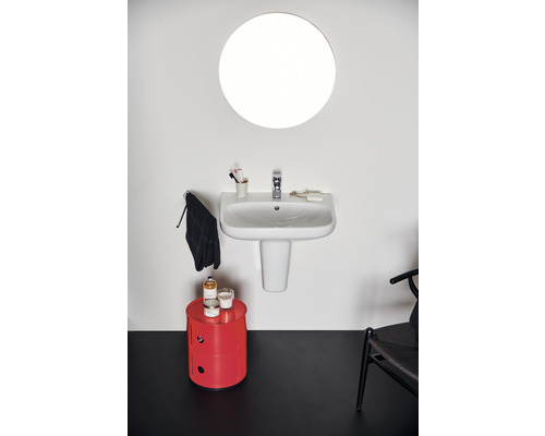 Salle de bains avec miroir rond, lavabo et armoire rouge