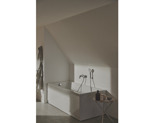 Badezimmer mit Badewanne, Armatur und Duschkopf unter einer Dachschräge