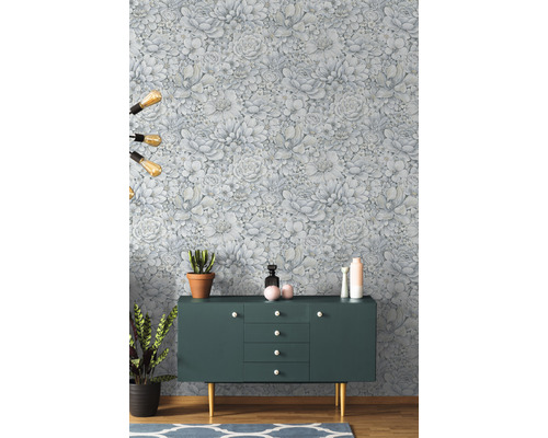Raumansicht mit Blumentapete, Sideboard und Zimmerpflanzen.