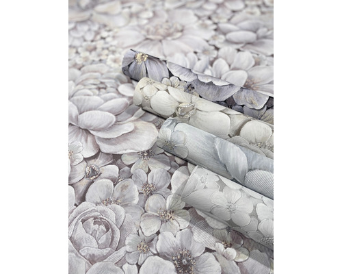 Drei Rollen Tapete mit Blumenmuster.