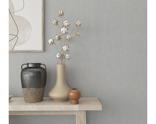 Dekorative Vasen auf einem Holztisch vor einer grauen Wand