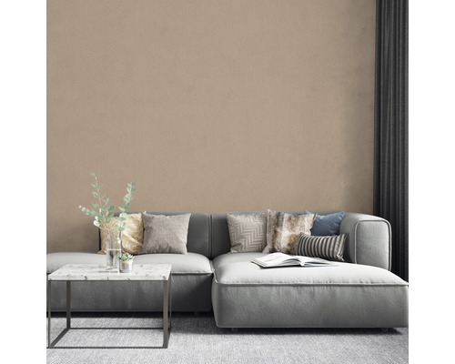 Wohnzimmer mit Couch, Kissen, Tisch und dekorativer Wand