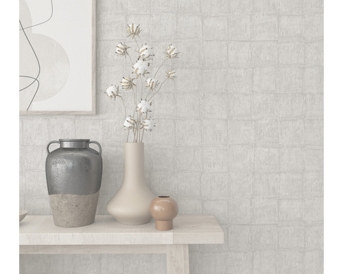 Helle Wohnraumszene mit Dekorationsgegenständen auf einem Tisch und einer gemusterten Tapete