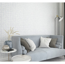 Helles Wohnzimmer mit Sofa, Kissen, Beistelltischen und gemusterter Tapete