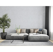 Wohnzimmer mit Sofa, Kissen, Tisch, Zimmerpflanze und gemusterter Tapete