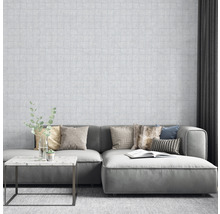 Wohnzimmer mit gemusterter Tapete, Sofa, Kissen und Tisch