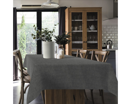 Table à manger avec nappe grise dans une pièce lumineuse