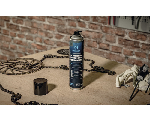 Nettoyant pour freins à disque Bike Broz avec chaîne de vélo et disque de frein sur une table