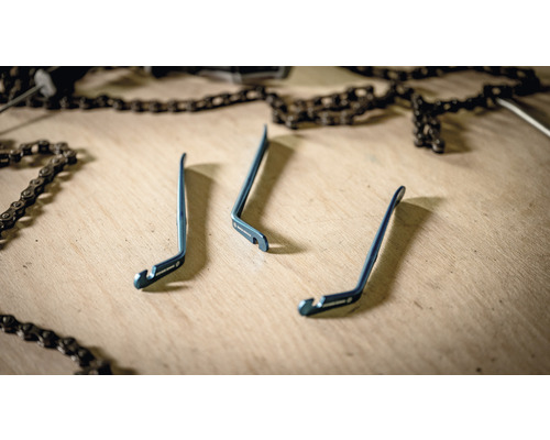 Drei Reifenheber aus Metall auf einer Holzoberfläche mit Fahrradkette