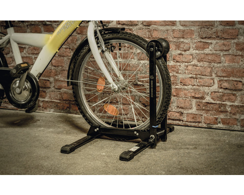 Vélo avec support à vélo devant un mur en briques