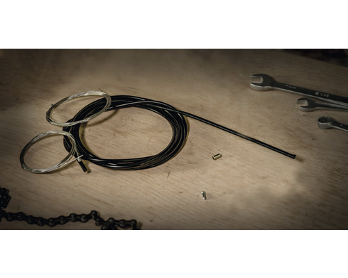 Jeu de câbles de dérailleur de vélo avec outils sur table en bois