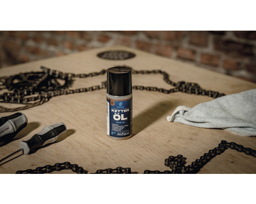 Fahrrad Kettenöl auf einer Holzoberfläche mit Werkzeugen und einer Kette