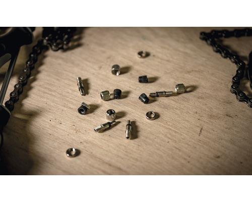 Valves de vélo et chaîne de vélo sur une surface en bois