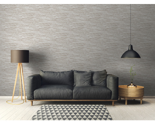 Wohnzimmer mit Sofa, Stehlampe und Pendelleuchte vor einer strukturierten Wand