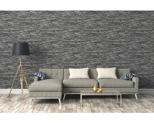 Salon avec papier peint imitation pierre grise, canapé, lampadaire et table basse.