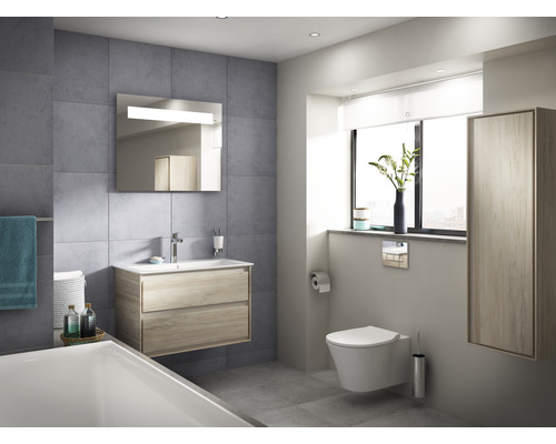 Salle de bains lumineuse avec meuble sous-lavabo, miroir avec éclairage et WC suspendu