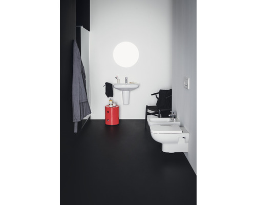 Badezimmer mit Waschtisch, Toilette, Bidet und rotem Hocker