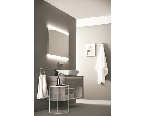 Badezimmer mit Waschtisch, Spiegel mit Beleuchtung und Handtuchhaltern für eine moderne Einrichtung