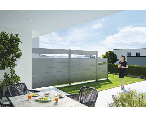 Scène de jardin avec éléments de clôture, table de jardin et chaises sur une terrasse