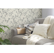 Wohnzimmer mit grauer Couch, Kissen und floraler Tapete