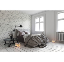 Helles Schlafzimmer mit Bett, Nachttisch und dekorativer Tapete