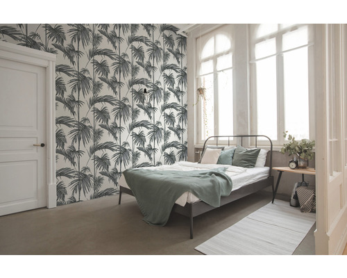 Schlafzimmer mit Bett und Tapete mit Palmenmuster