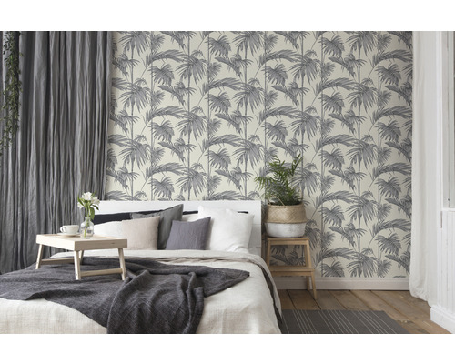 Schlafzimmer mit Bett und Tapete mit Palmenmuster