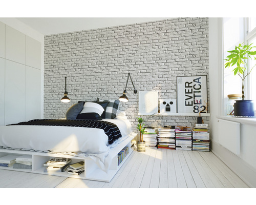 Schlafzimmer mit Bett, Nachttisch und Ziegelwandtapete