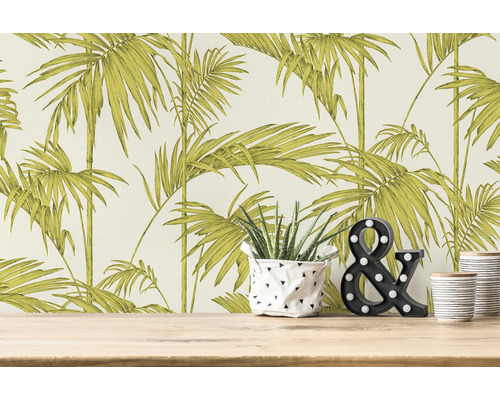 Raumszene mit Palmenmuster-Tapete, Pflanze und dekorativem &-Zeichen auf einem Holztisch.