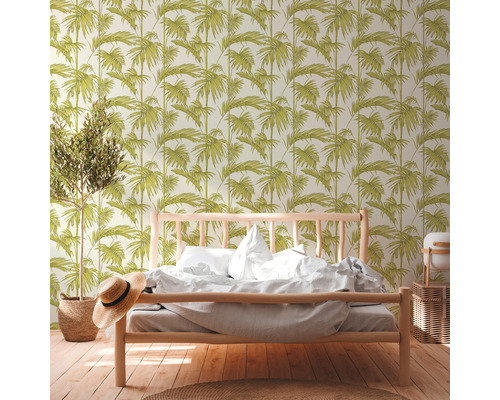 Ein Schlafzimmer mit einem Bett und einer Tapete mit Blattmuster.