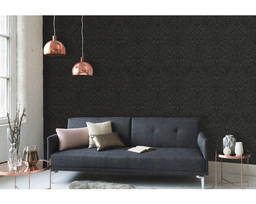 Wohnzimmer mit grauer Couch, gemusterter Tapete und zwei Hängelampen