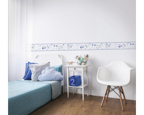 Kinderzimmer mit Bordüre mit Weltraummotiven, Bett, Nachttisch und Stuhl.