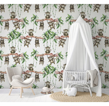 Kinderzimmer mit Affenmuster-Tapete, Babybett und Sessel
