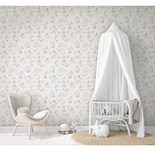 Kinderzimmer mit Hasentapete, Sessel und Babybett mit Baldachin.