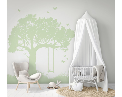 Kinderzimmer mit Baum Wandtattoo, Stuhl und Babybett mit Baldachin.