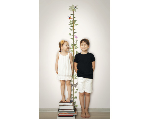 Des enfants se tiennent à côté d''un tableau de croissance avec des motifs d''animaux sur un mur