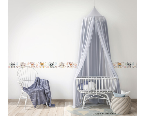 Kinderzimmer mit Wandbordüre, Babybett und Stuhl