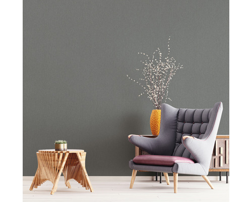 Wohnraum mit grauer Tapete, Sessel und Beistelltisch