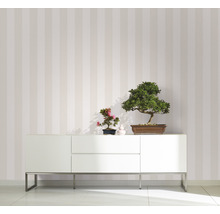 Pièce moderne avec papier peint rayé, buffet blanc et plantes bonsaï